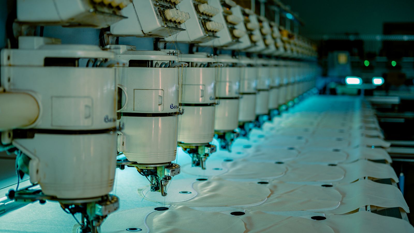 Rows of industrial sewing machines in a textile production facility